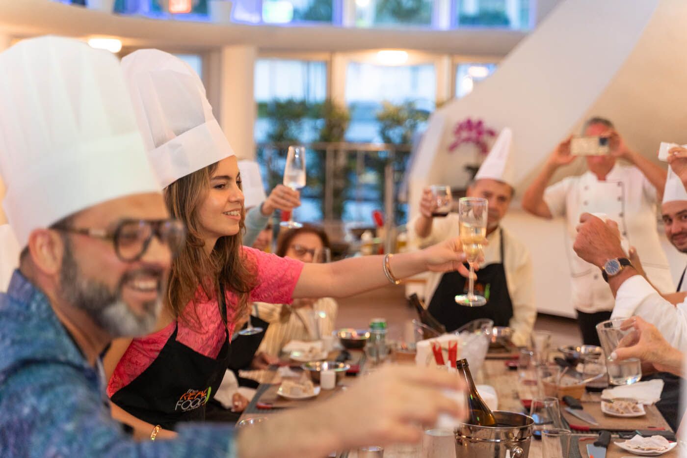 A group of adults drinking champaign at The Real Food Academy's couples cooking classes.