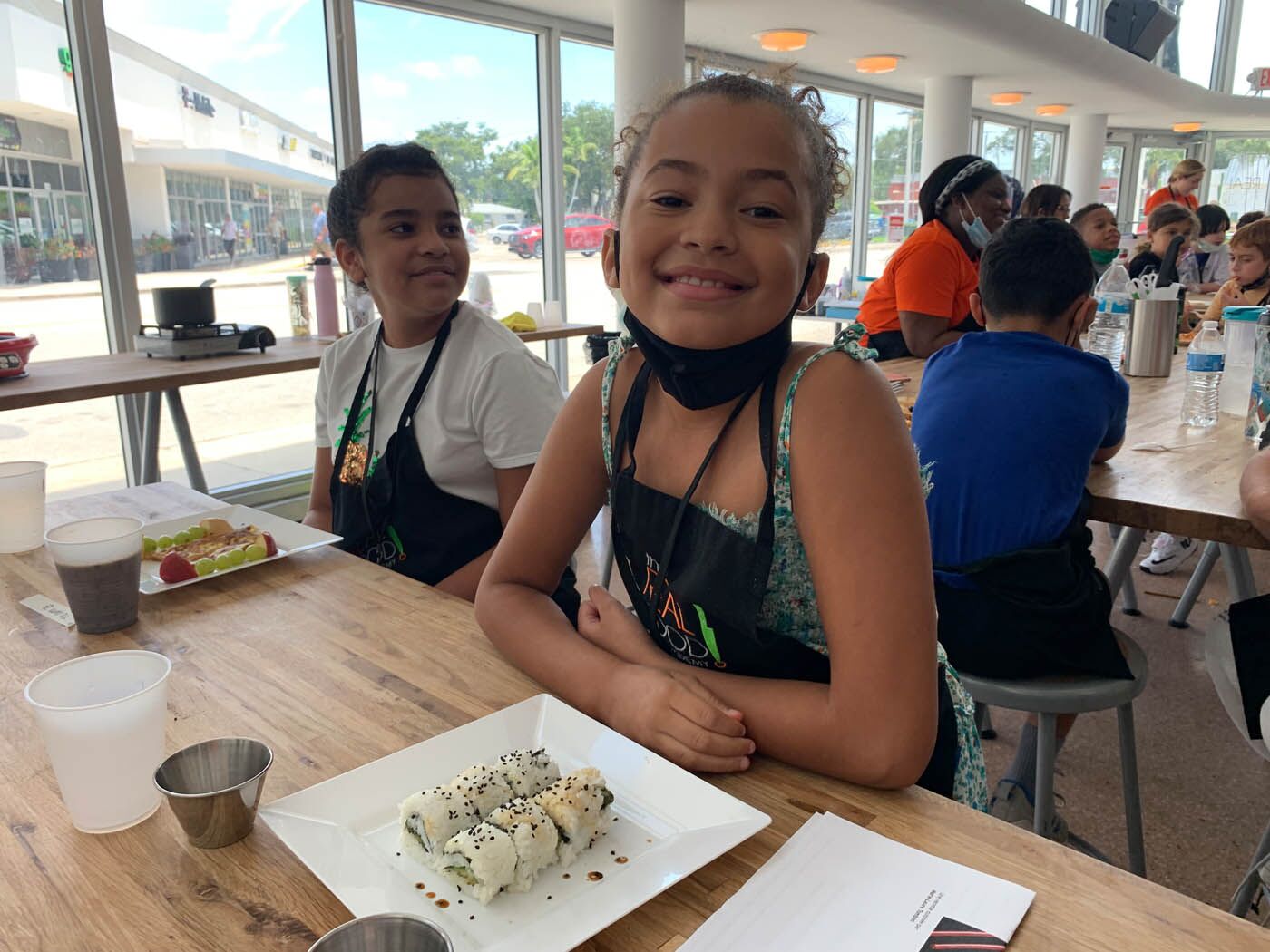 Two little girls sitting in front of their fresh meal at The Real Food Academy cooking camps.