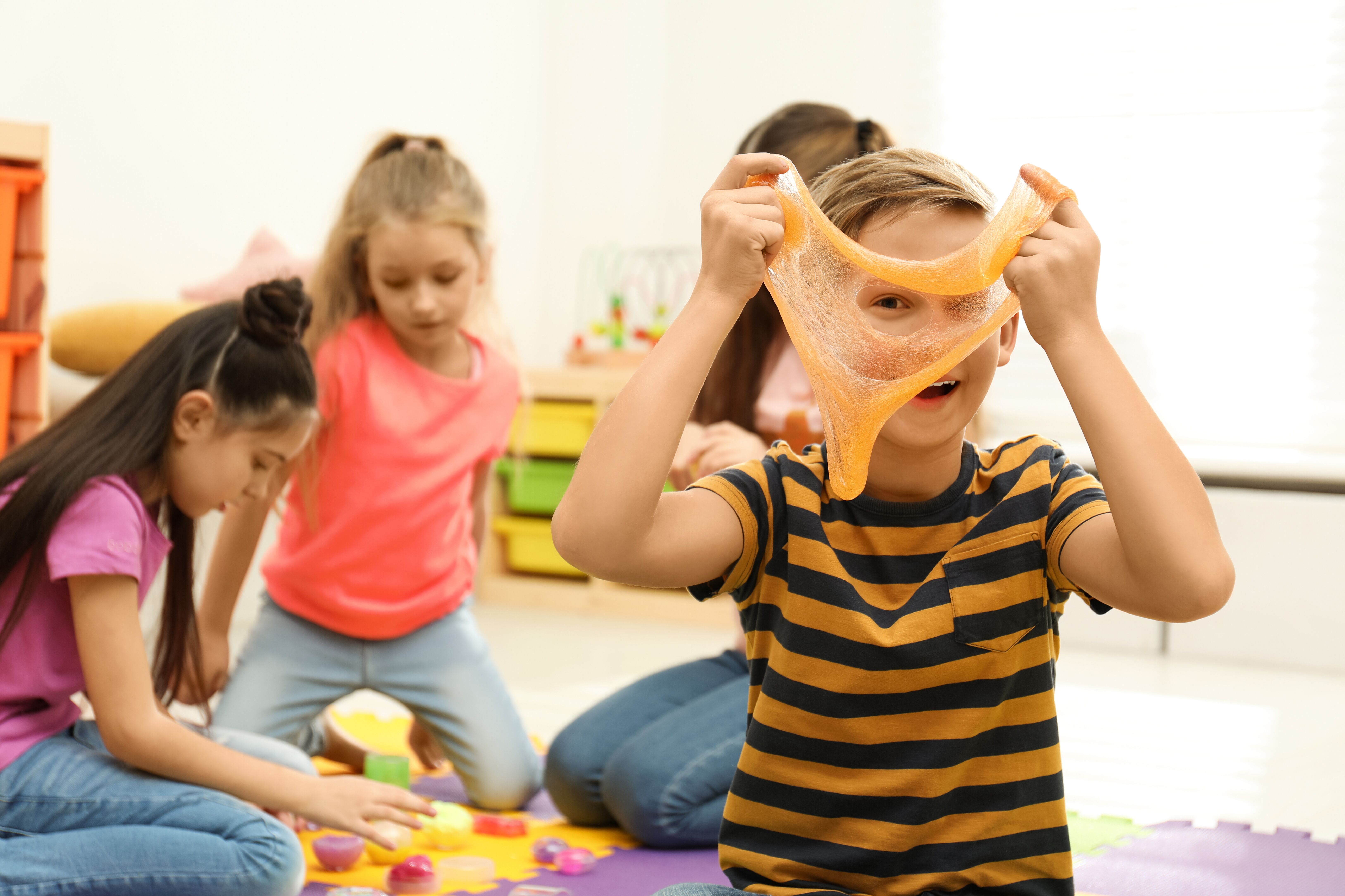 A group of children at a science themed party making slime.